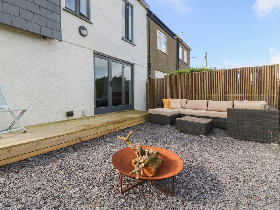 A garden with outdoor seating and a fire pit at Seren Fach Pwllheli