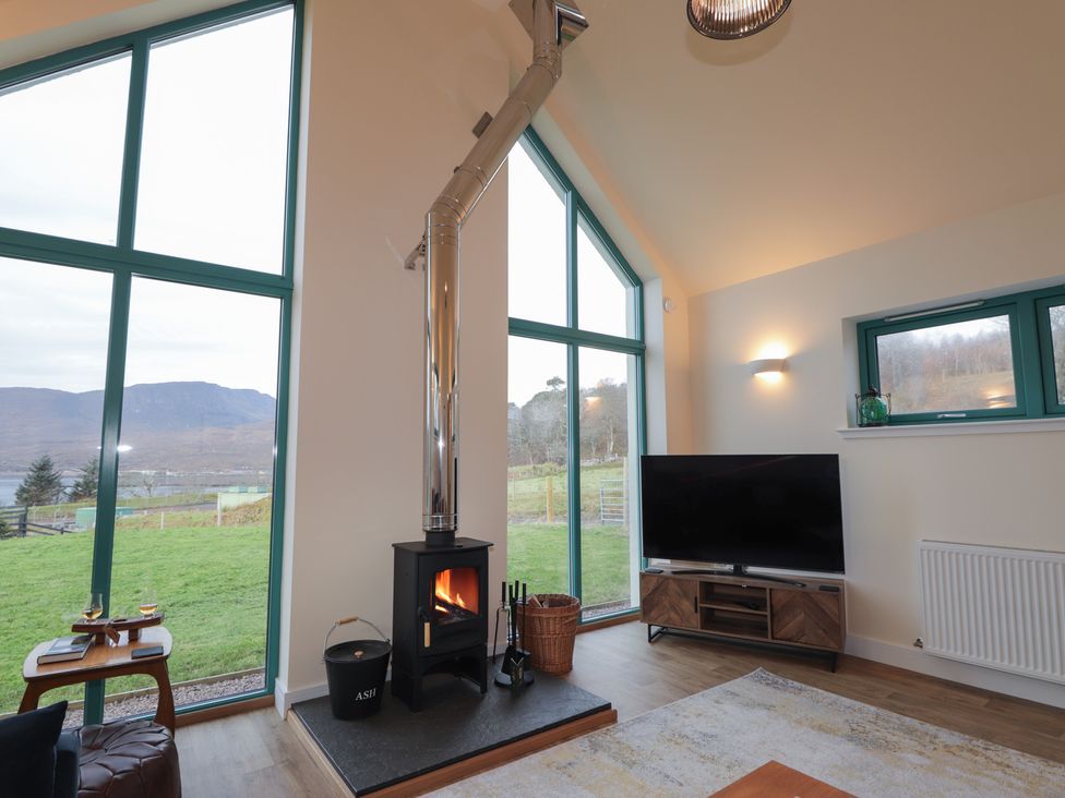 A living room with a fireplace and television at Sonas in Strathcarron