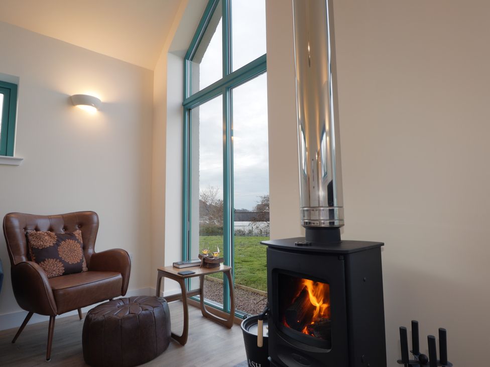 A living room with a stove and armchair at Sonas in Strathcarron