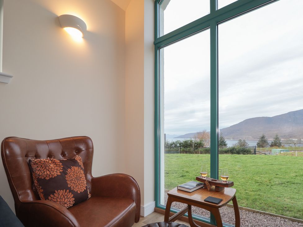 A living room with an armchair and side table at Sonas in Strathcarron
