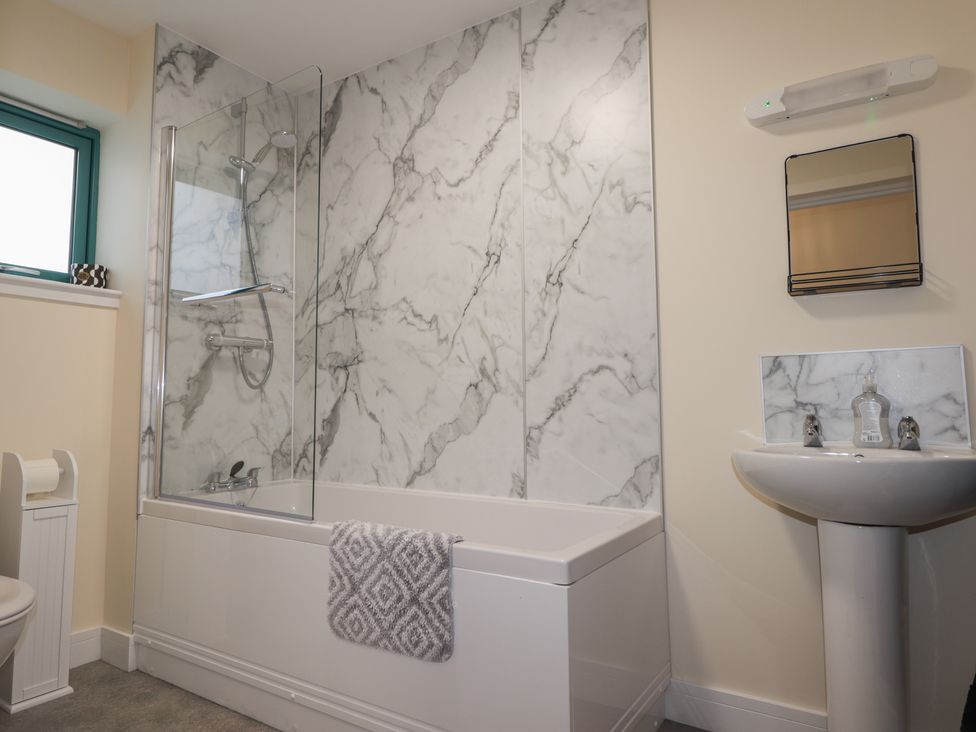A bathroom with a bathtub and sink at Sonas in Strathcarron