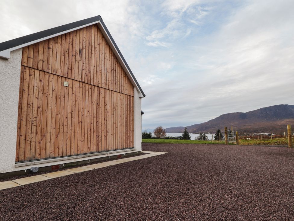 A building with wooden wall and gravel area at Sonas in Strathcarron