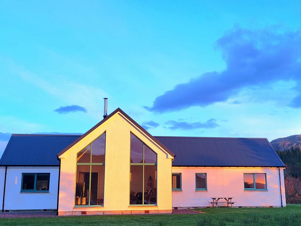 A house with large windows and a picnic table at Sonas Lochcarron