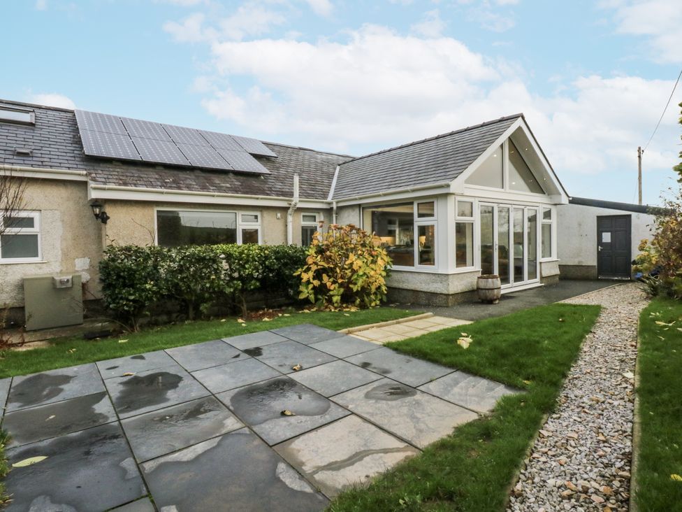 An outdoor view of a house with solar panels at Benlli Pwllheli