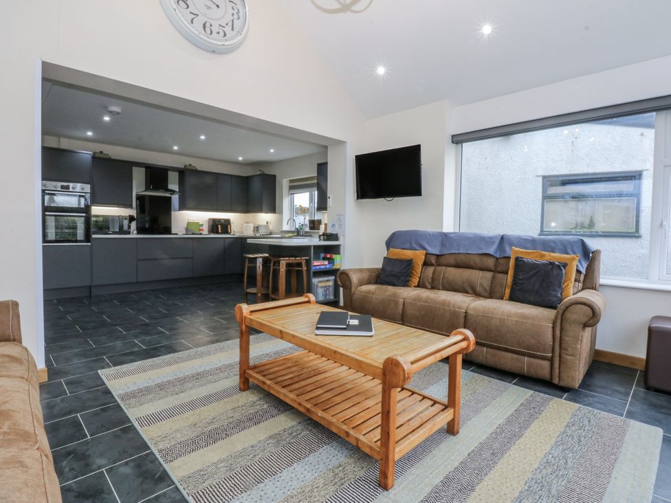 A living room with a sofa and coffee table at Benlli in Pwllheli