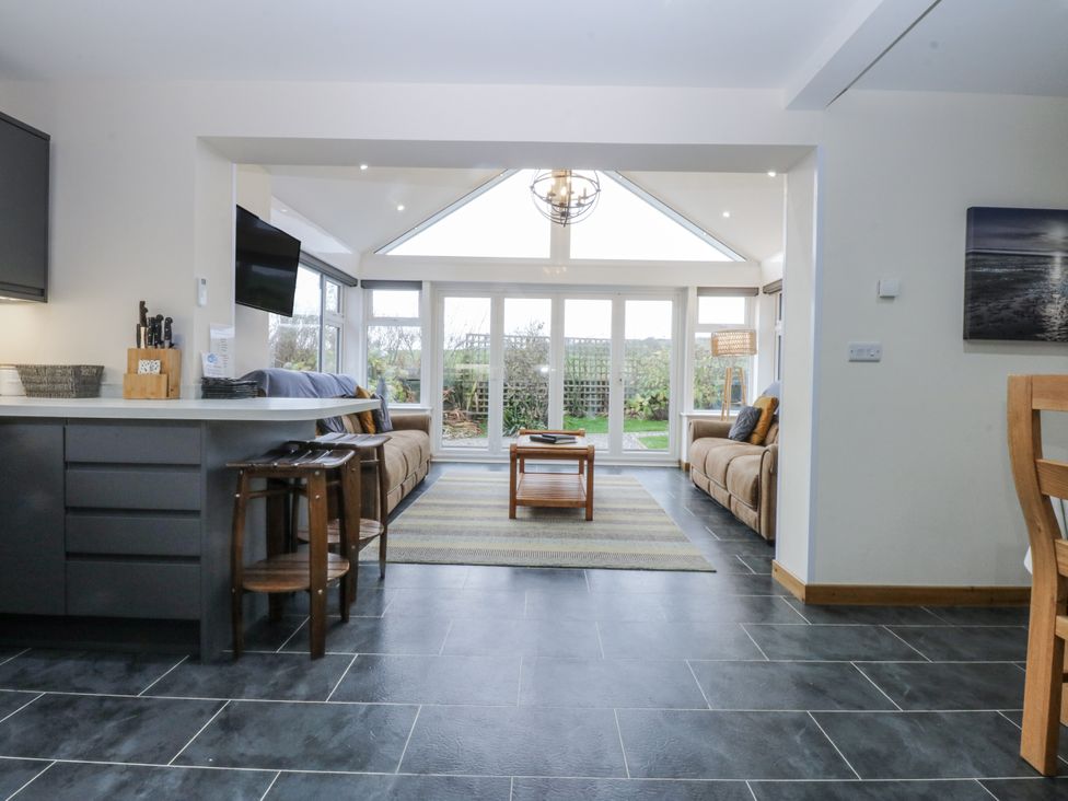 A living room with a sofa and coffee table at Benlli in Pwllheli