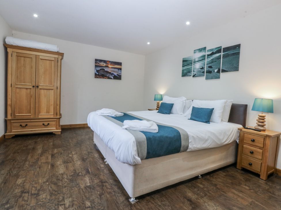 A bedroom with a bed and wardrobe at Benlli in Pwllheli
