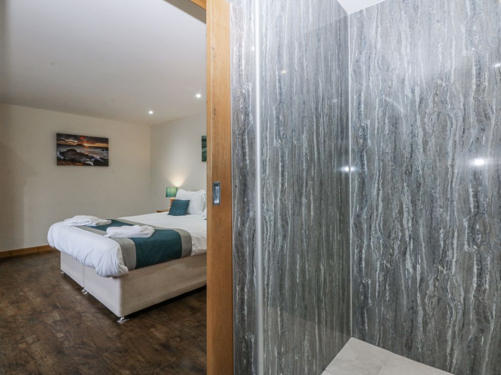 A bedroom with a bed and a shower at Benlli in Pwllheli