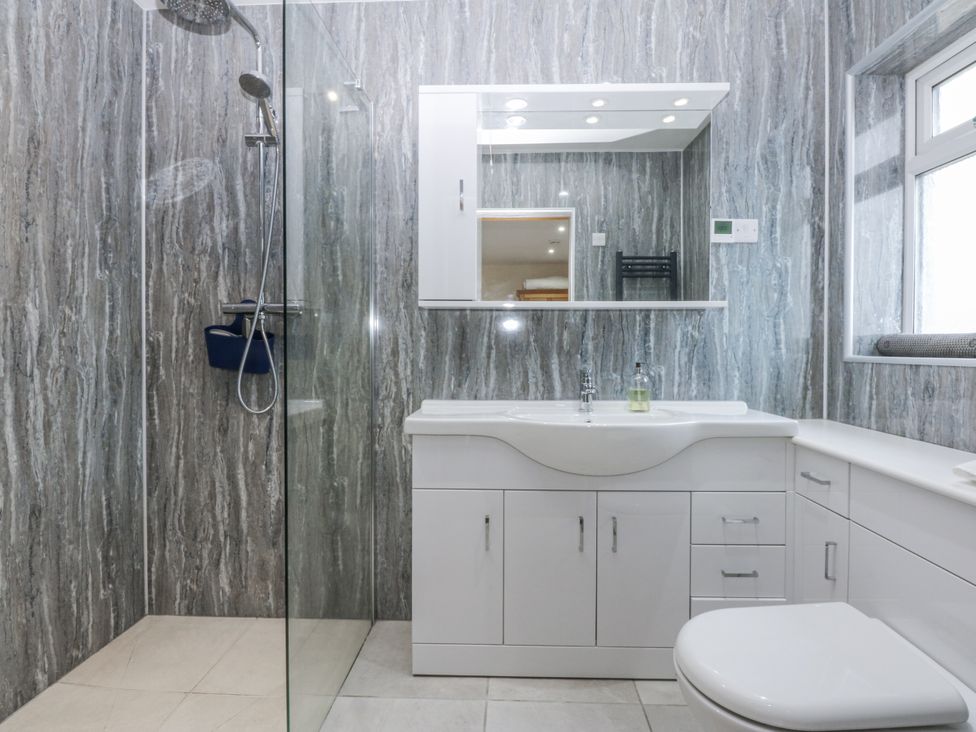 A bathroom with a shower and vanity unit at Benlli in Pwllheli