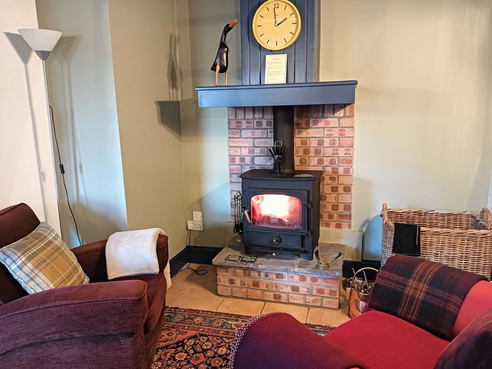 A snug with a fireplace and two chairs at Claymires Stirling