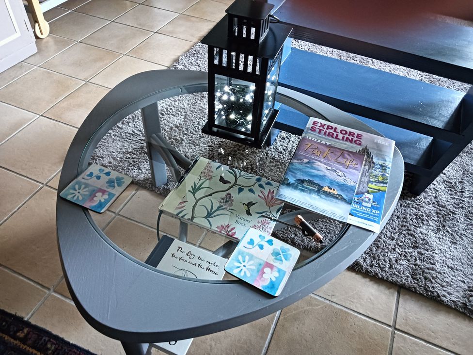 A coffee table with a lantern and magazines at Claymires in Stirling