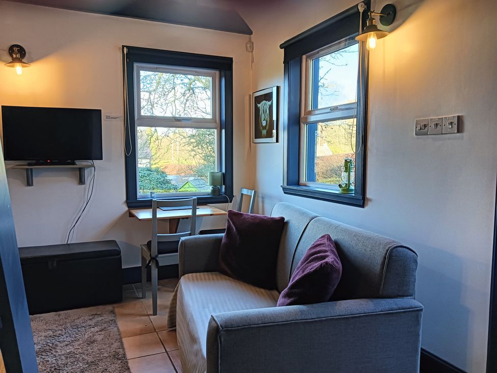 A living room with a sofa and television at Claymires in Stirling