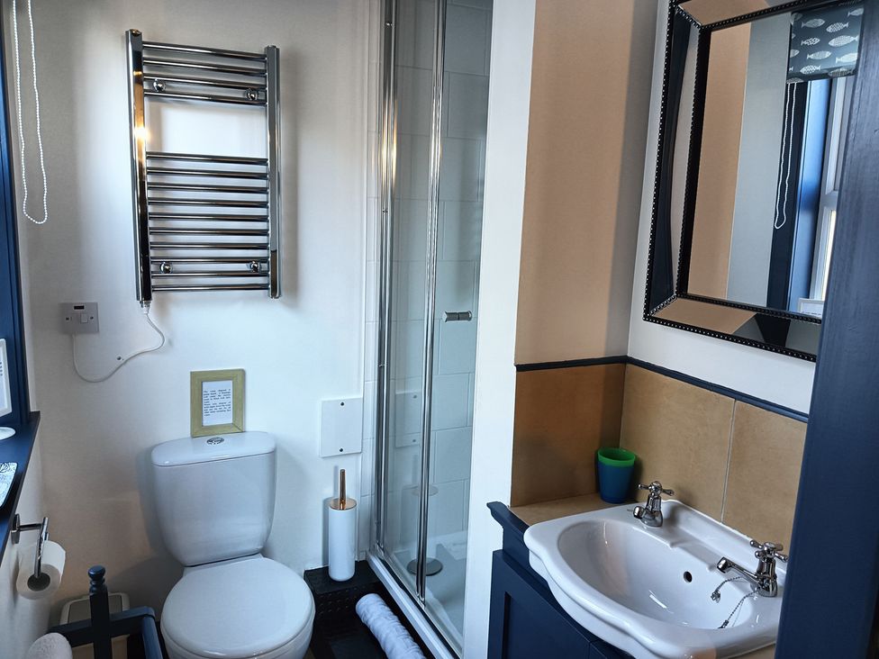 A bathroom with a shower, sink, toilet and towel rail at Claymires in Stirling