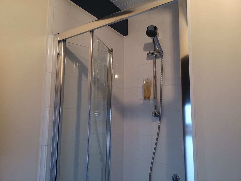 A shower with transparent door and wall-mounted showerhead at Claymires Stirling
