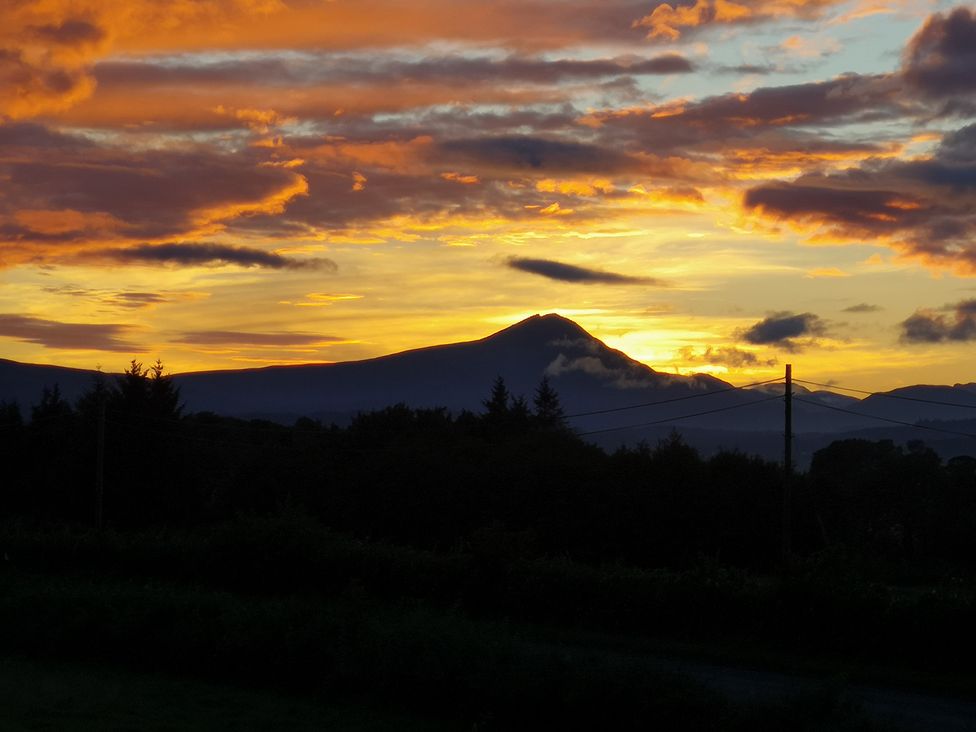 A sunset view with mountains and trees at Claymires Stirling