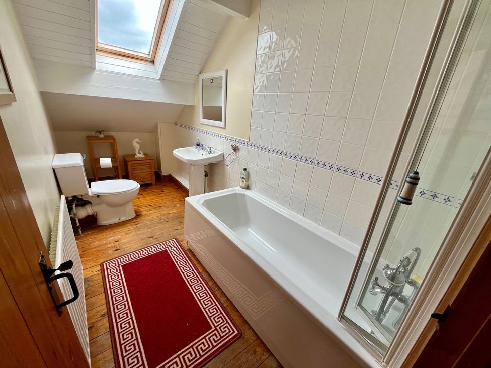 A bathroom with a bathtub, toilet, sink and mirror at Starshinezzz Trimdon Station