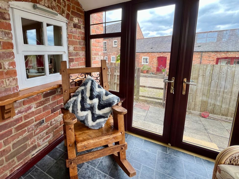 A conservatory with a rocking chair and a window at Starshinezzz in Trimdon Station