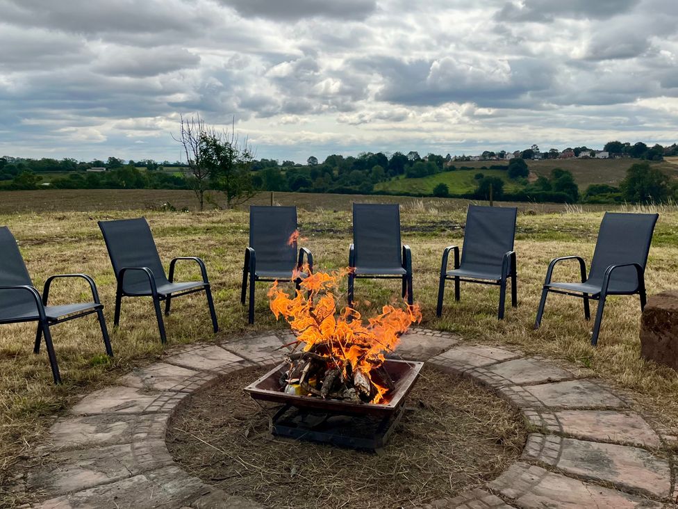 An outdoor fire pit with chairs around it at Starshinezzz in Trimdon Station