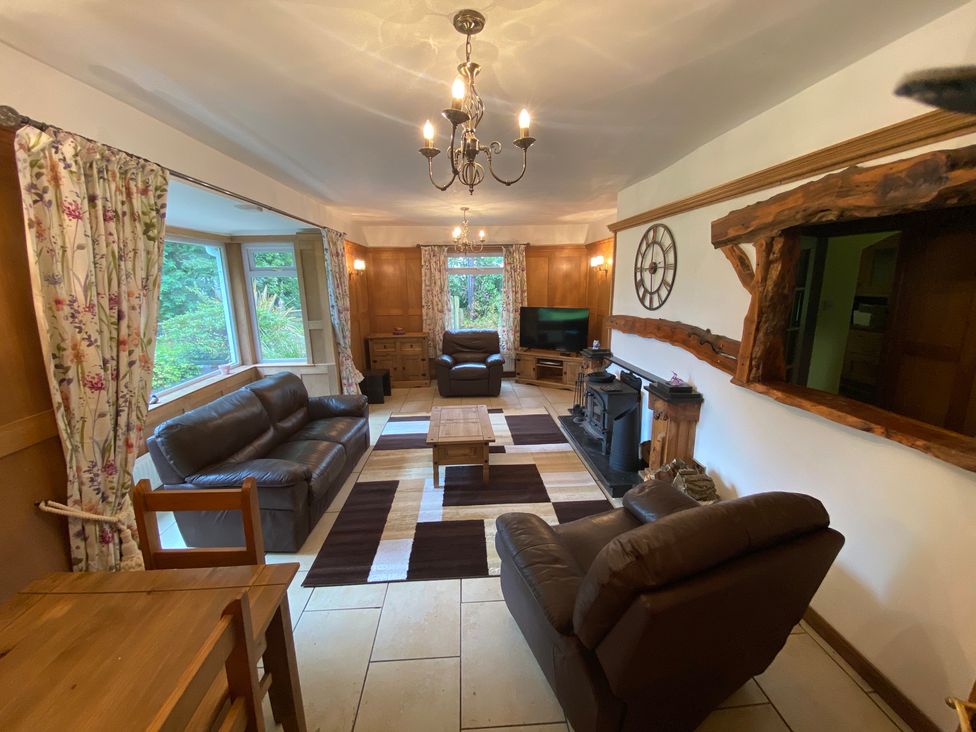 A living room with sofa and table at Whispering Trees Cottage Thornhill