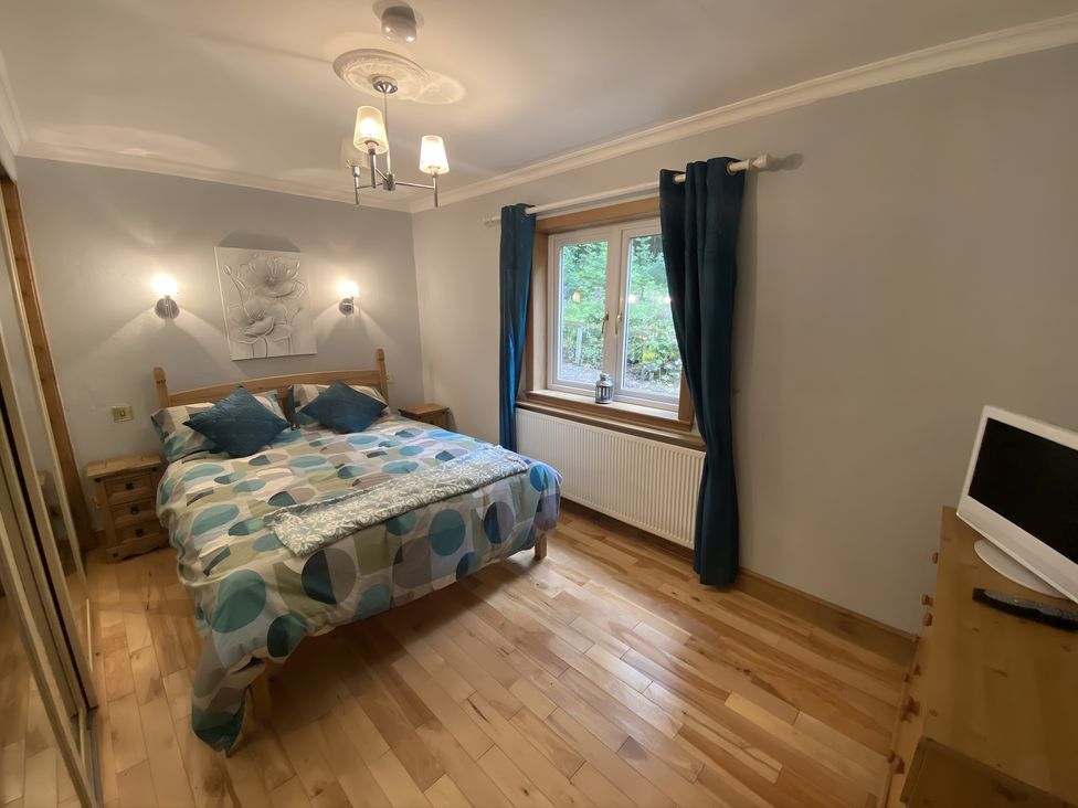 A bedroom with a bed and window at Whispering Trees Cottage Thornhill