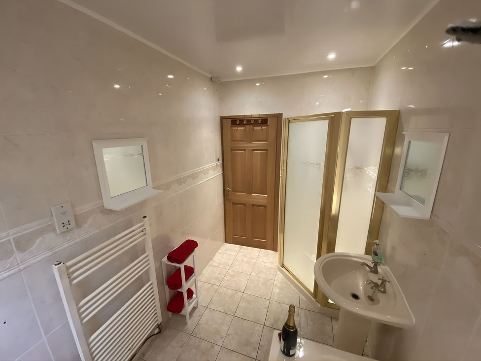 A bathroom with sink, shower enclosure and mirror at Whispering Trees Cottage in Thornhill