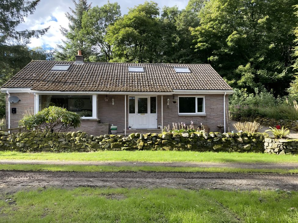 A house with windows and a door at Whispering Trees Cottage in Thornhill