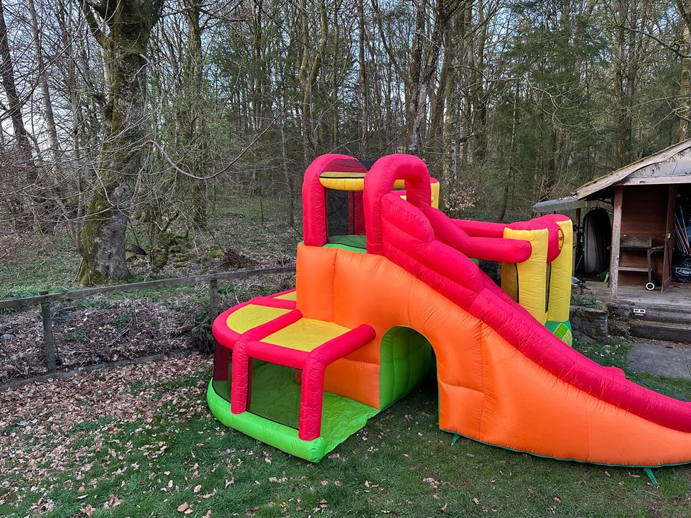 An inflatable bounce house with a slide in an outdoor area at Whispering Trees Cottage Thornhill