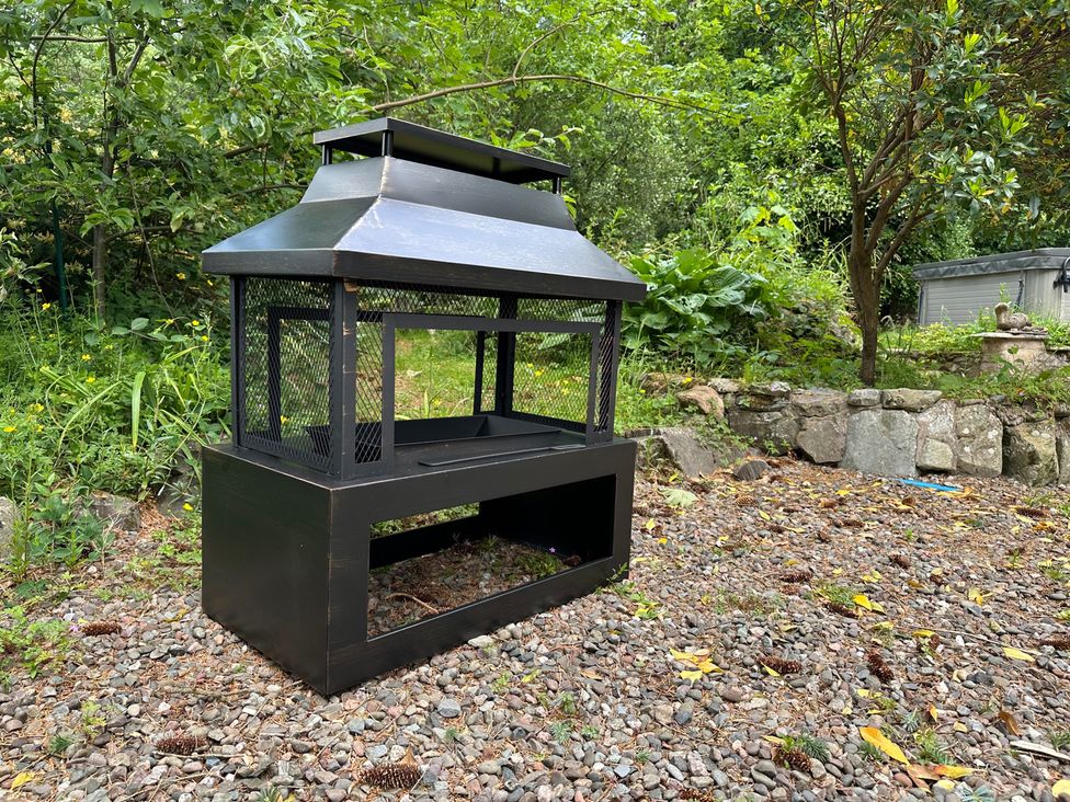 A fire pit on gravel in a garden at Whispering Trees Cottage Thornhill