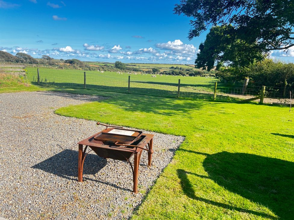 A grill on gravel with grass and a field at The lodge at Plumstone View Haverfordwest