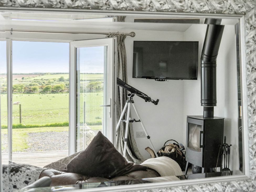 A living room with a television and telescope at The lodge at Plumstone View in Letterston