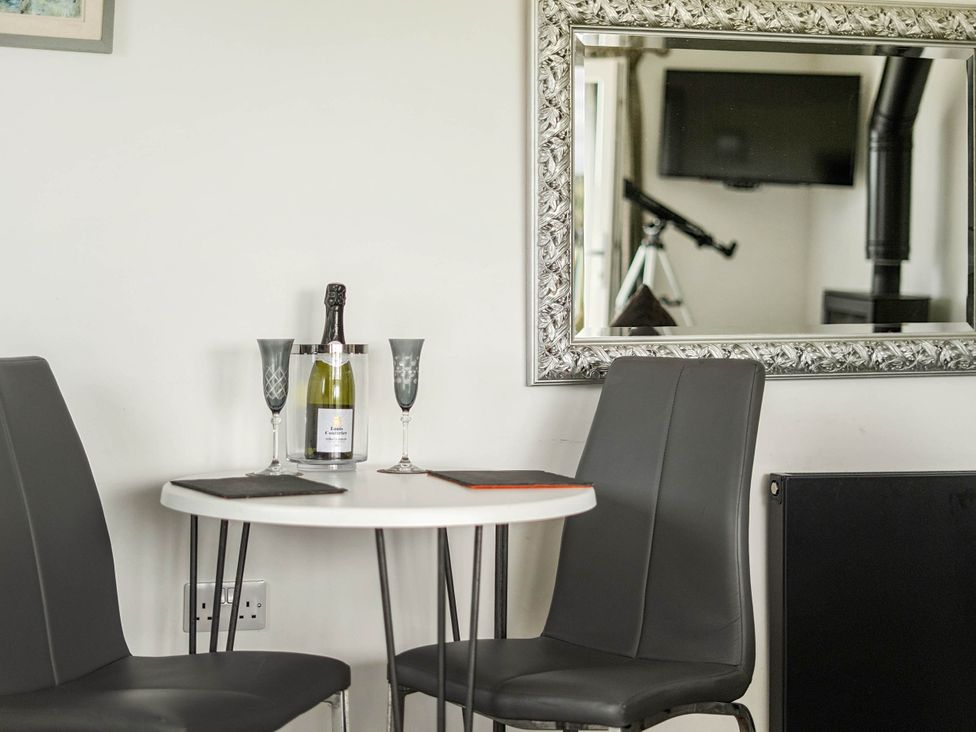 A dining area with champagne on the table at The lodge at Plumstone View Letterston