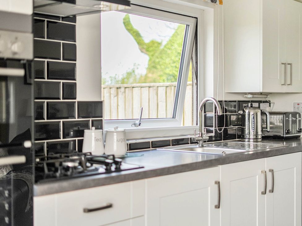 A kitchen with a window and appliances at The lodge at Plumstone View Letterston