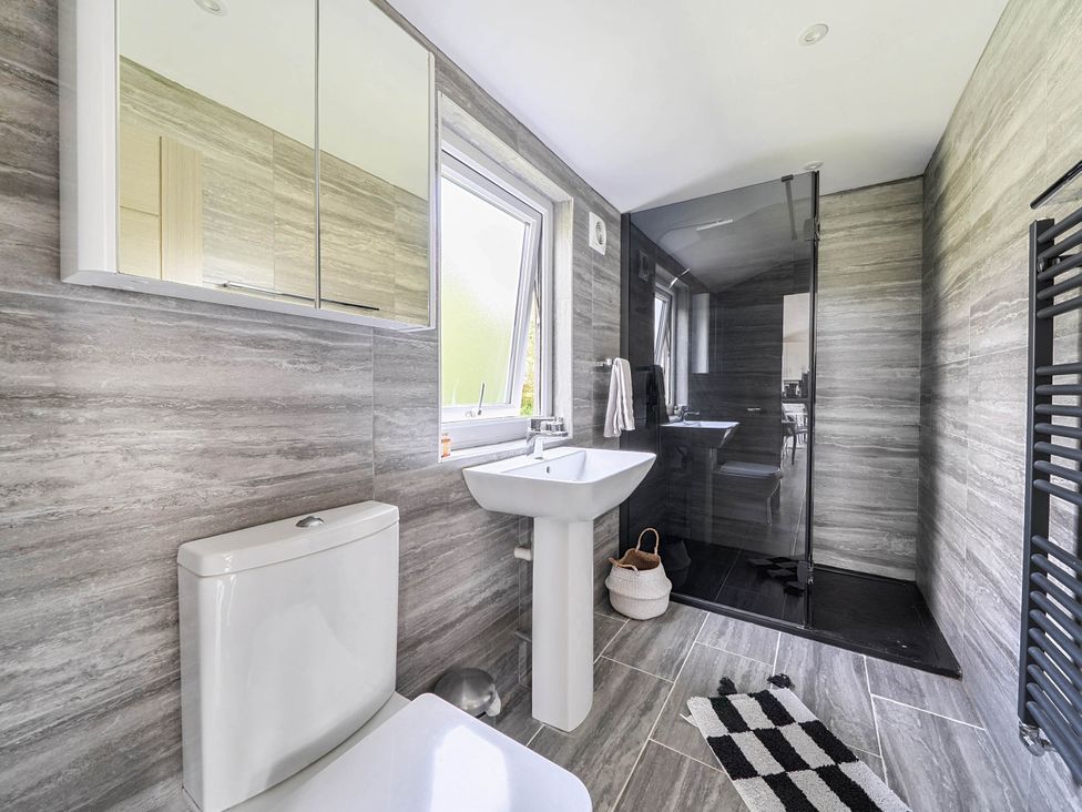A bathroom with a toilet, sink, and shower at The lodge at Plumstone View in Letterston