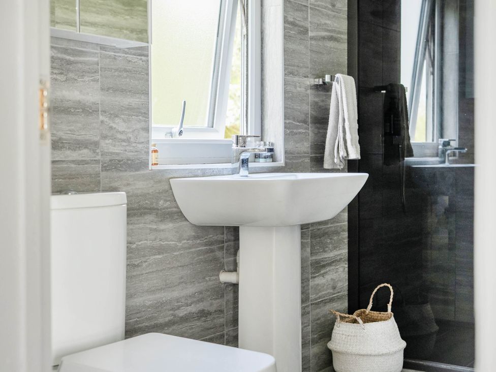 A bathroom with a toilet, sink, and shower at The lodge at Plumstone View in Letterston