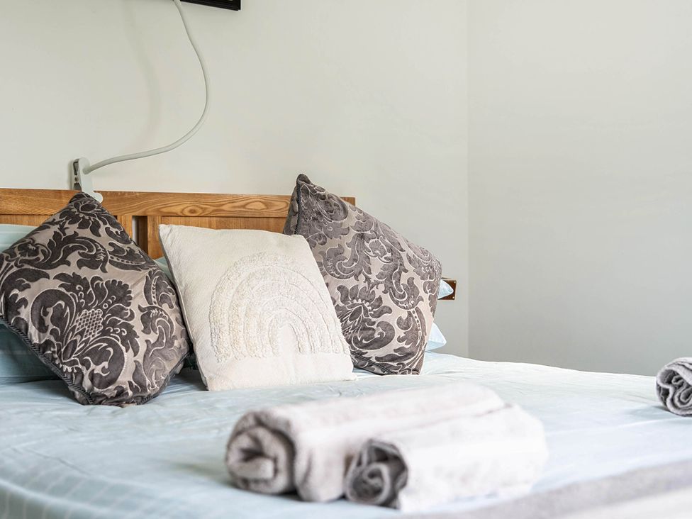 A bedroom with pillows and towels on a bed at The lodge at Plumstone View in Letterston