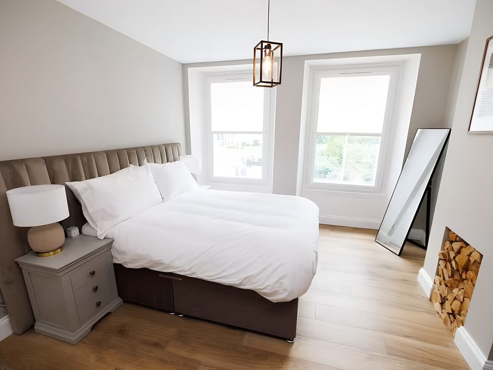 A bedroom with a bed and nightstand at Robert the Bruce Apartment, Dunfermline