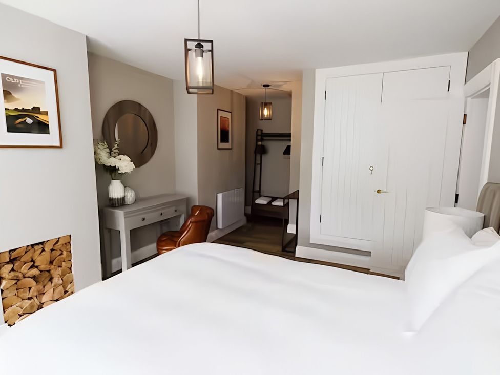 A bedroom with a bed, nightstand, and mirror at Robert the Bruce Apartment in Dunfermline