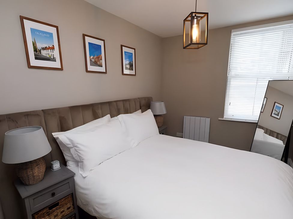 A bedroom with a bed and bedside table at Robert the Bruce Apartment in Dunfermline