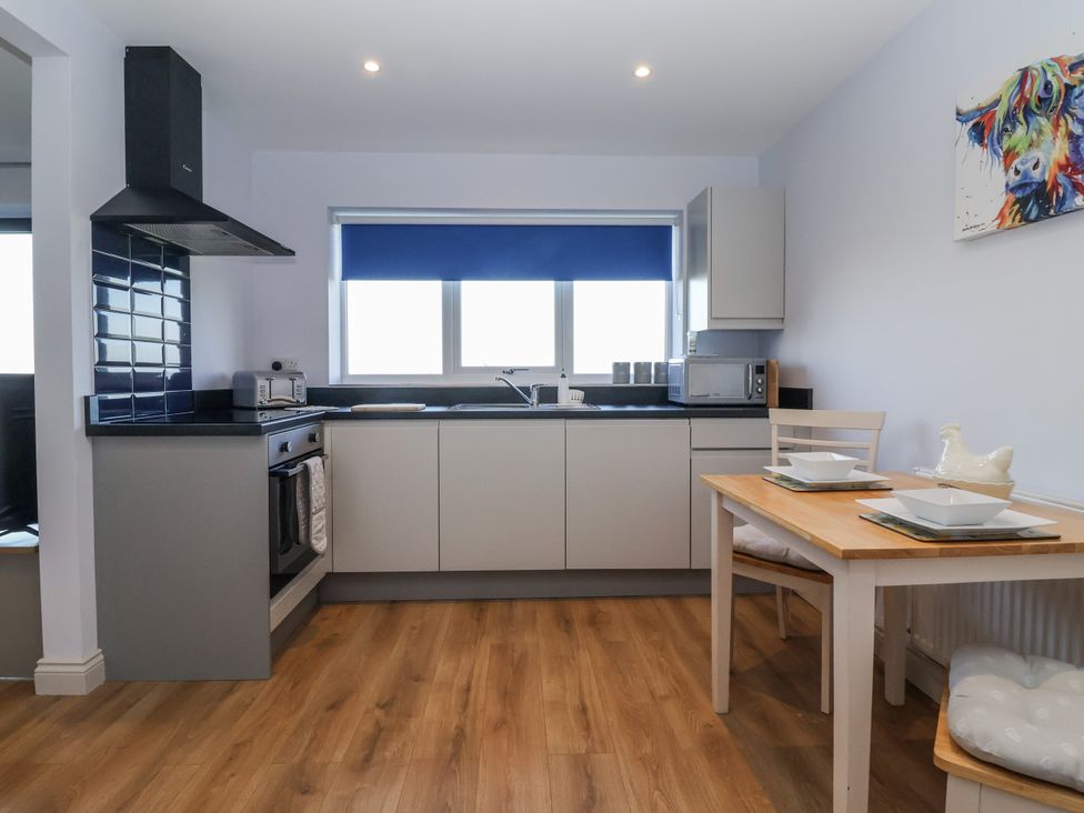 A kitchen with appliances and dining table at Genesis in Richmond