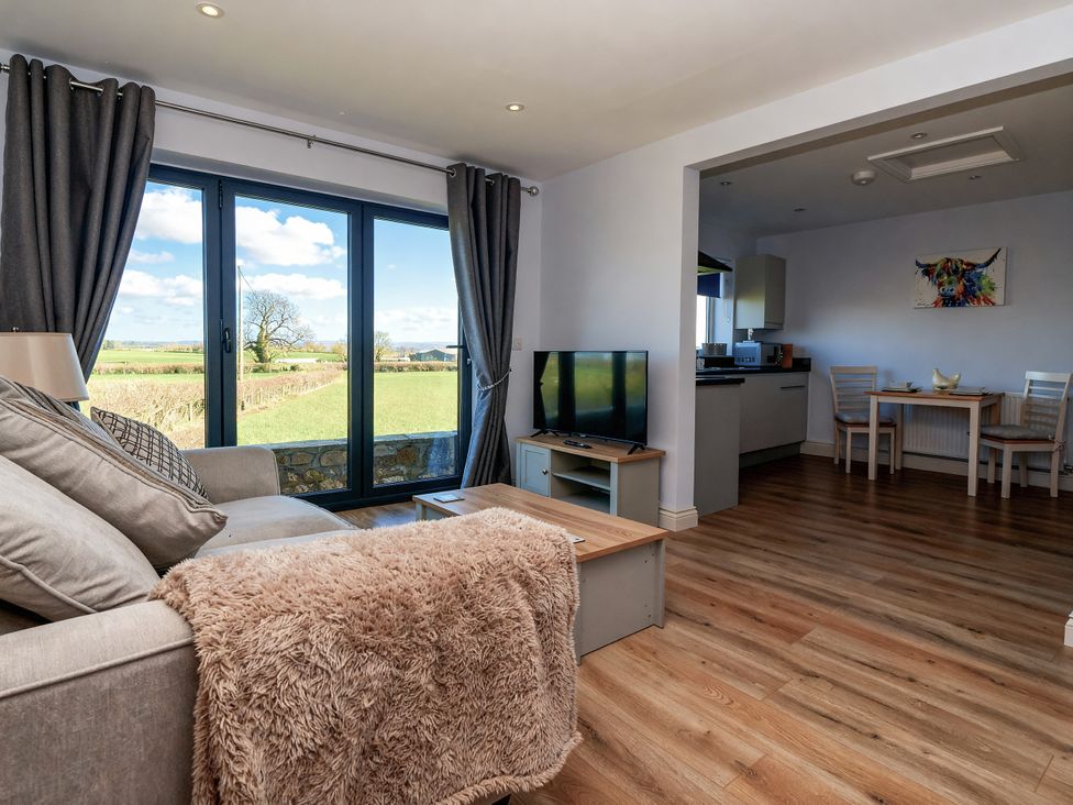 A living room with a sofa and television at Genesis in Richmond