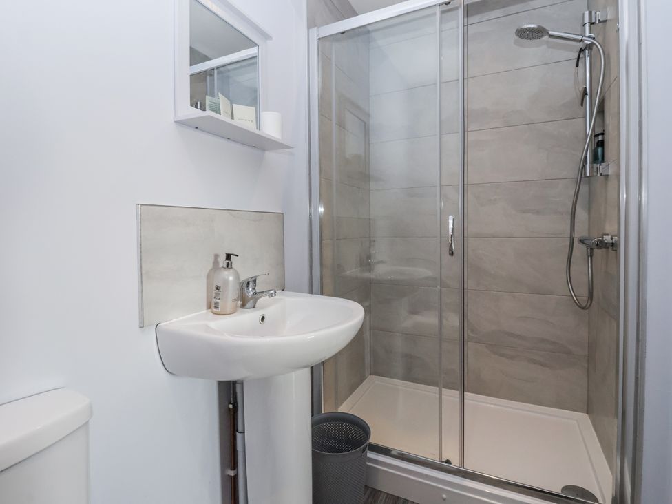 A bathroom featuring a sink, shower, toilet, and mirror at Fleetwood in Richmond