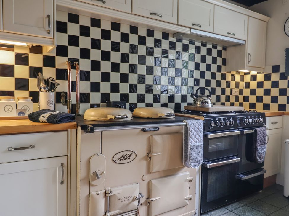 A kitchen with stove, kettle and cooking utensils at Ellishayes Farm in Combe Raleigh