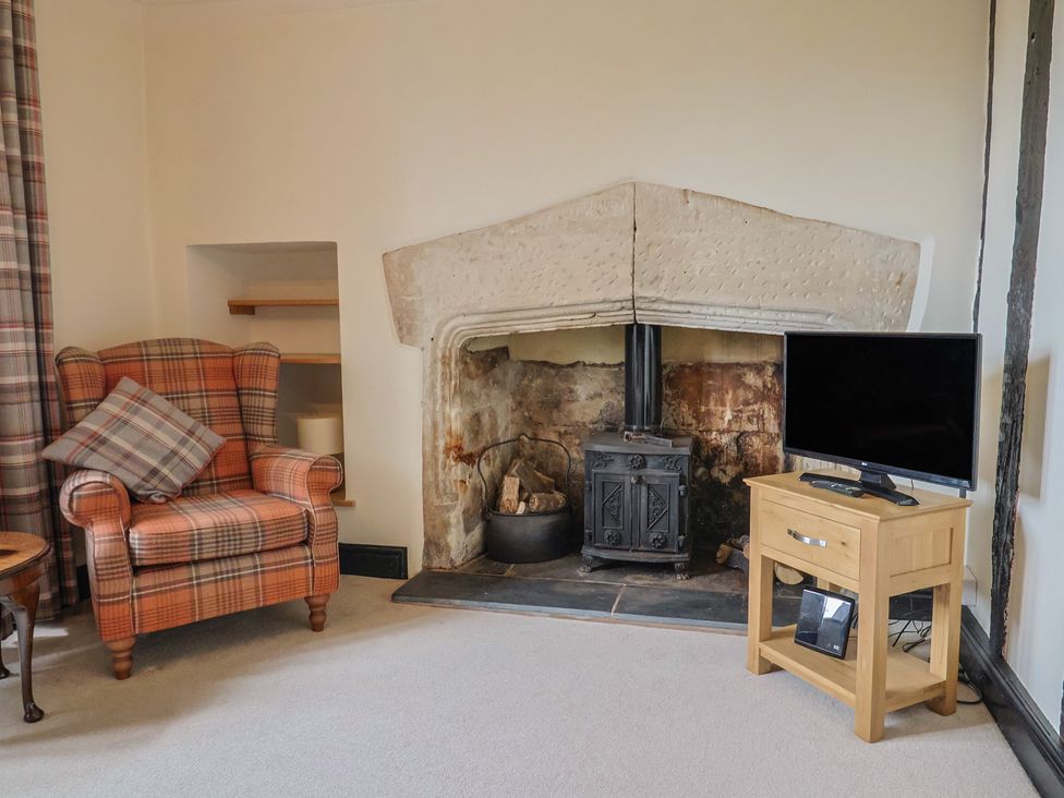 A living room with an armchair and television at Ellishayes Farm in Combe Raleigh