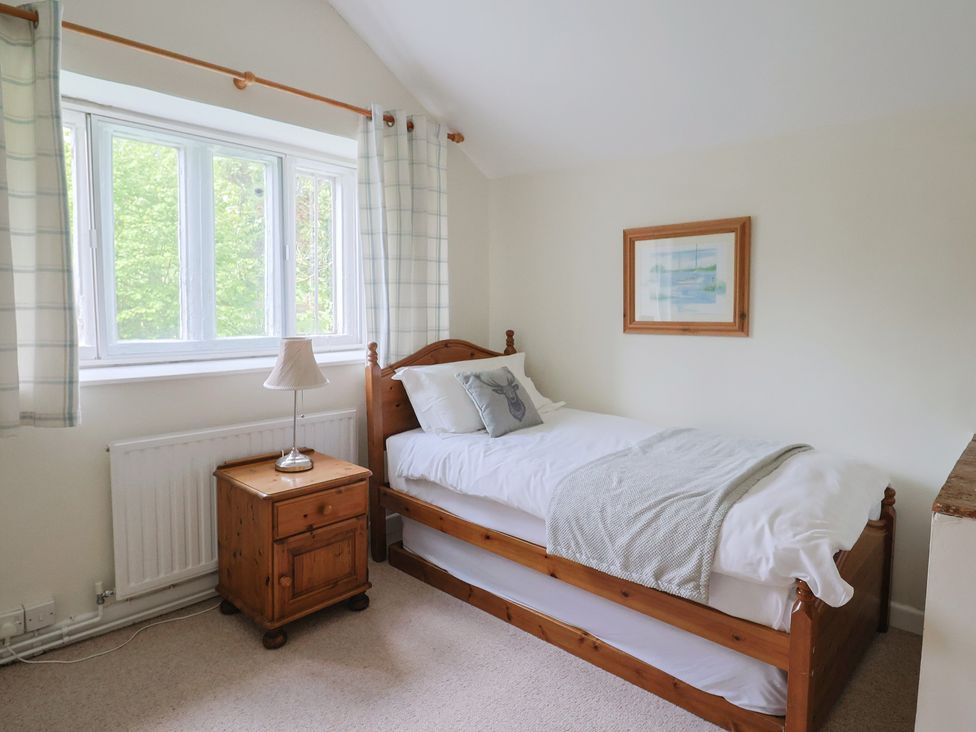 A bedroom with a single bed and a nightstand at Ellishayes Farm in Combe Raleigh