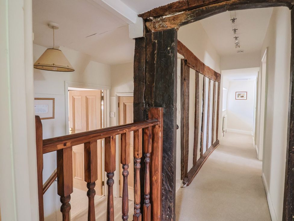 A hallway with a staircase and doors at Ellishayes Farm in Combe Raleigh
