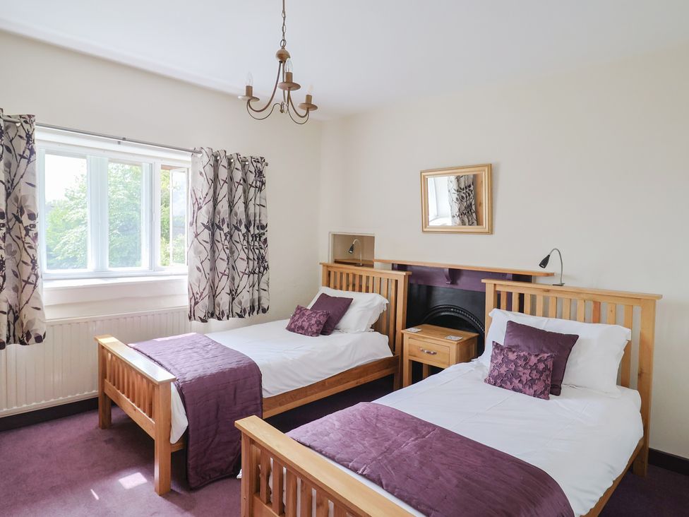 A bedroom with two beds and a window at Ellishayes Farm in Combe Raleigh
