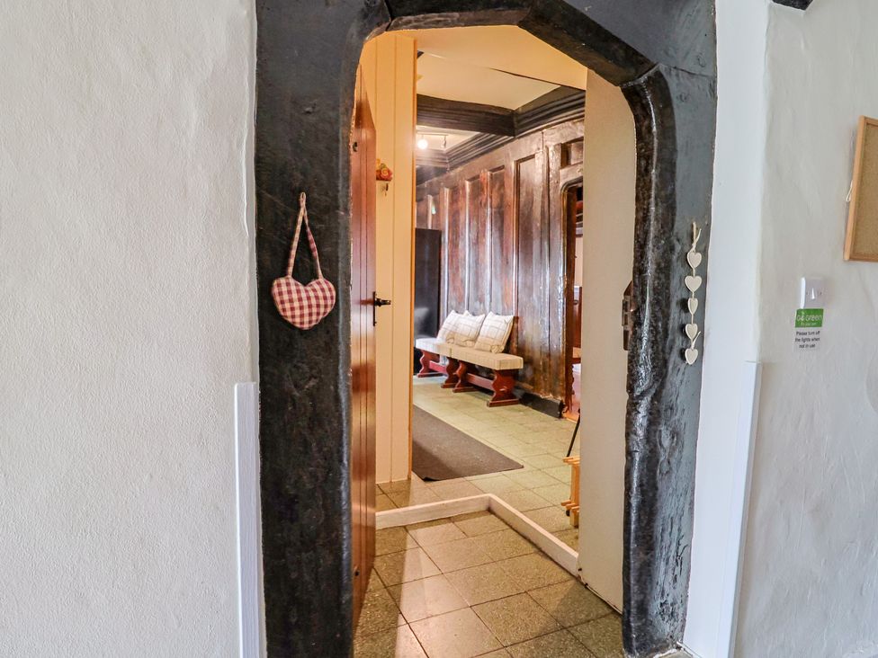 A hallway with a bench and a doorway at Ellishayes Farm in Combe Raleigh