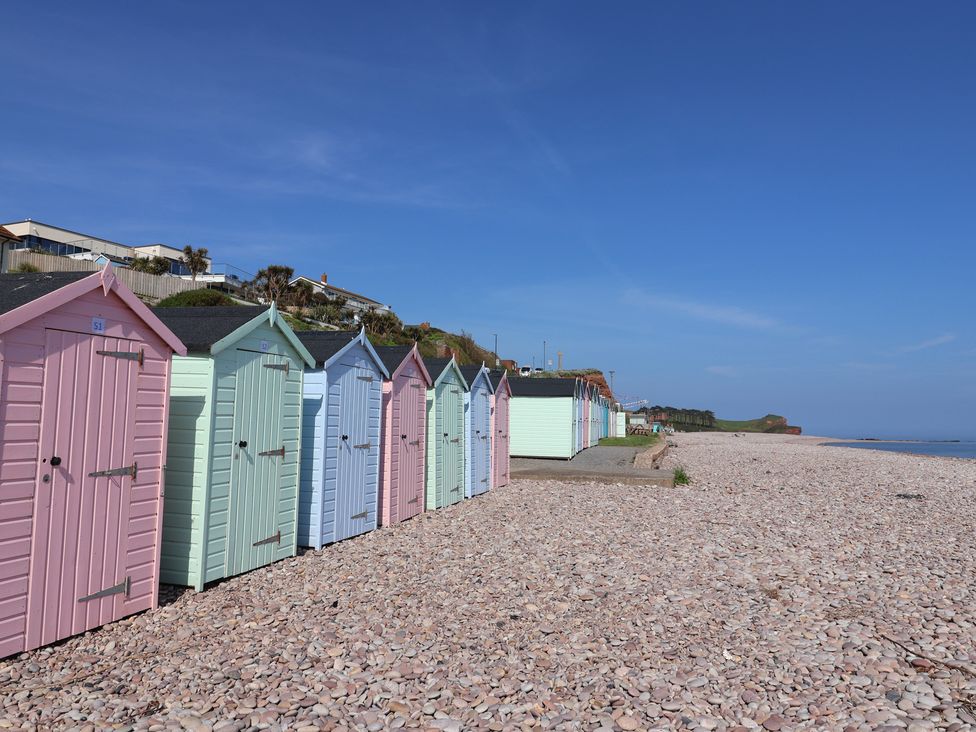 A row of beach huts on a pebbled beach at Ellishayes Farm in Combe Raleigh