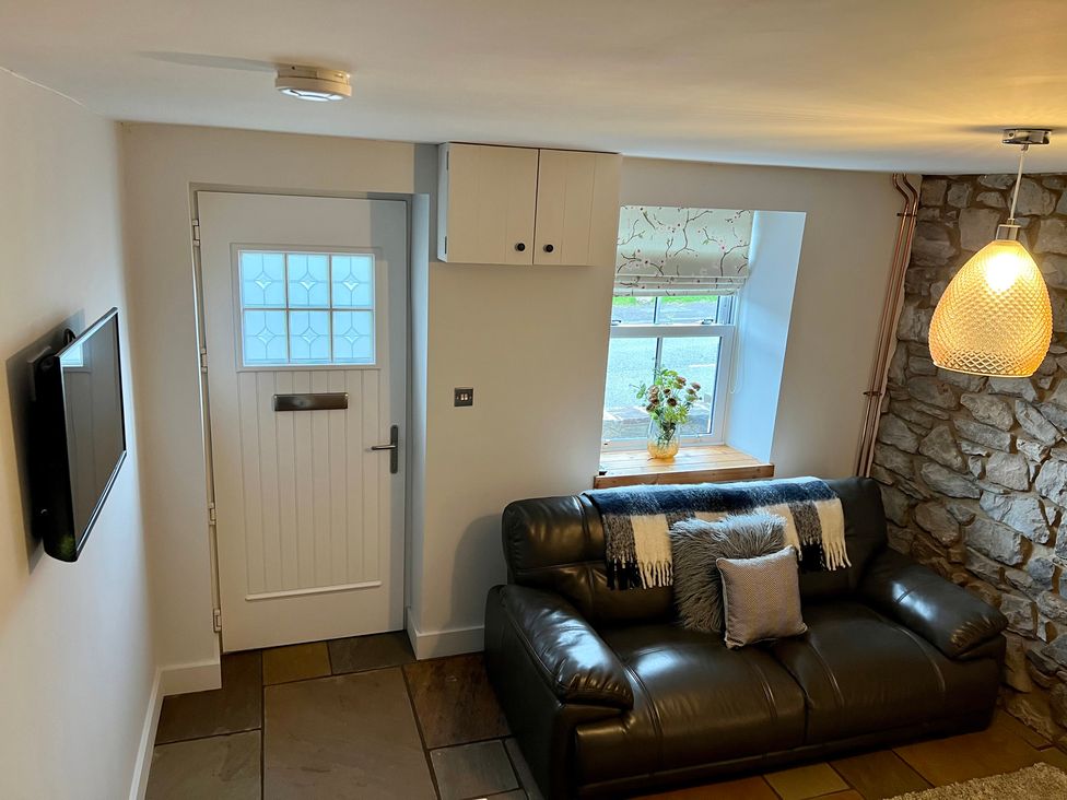 A living room with a sofa and television at Penderyn Cottage in Aberdare