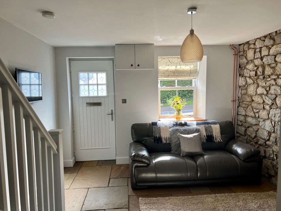 A living room with a sofa and a window at Penderyn Cottage Aberdare